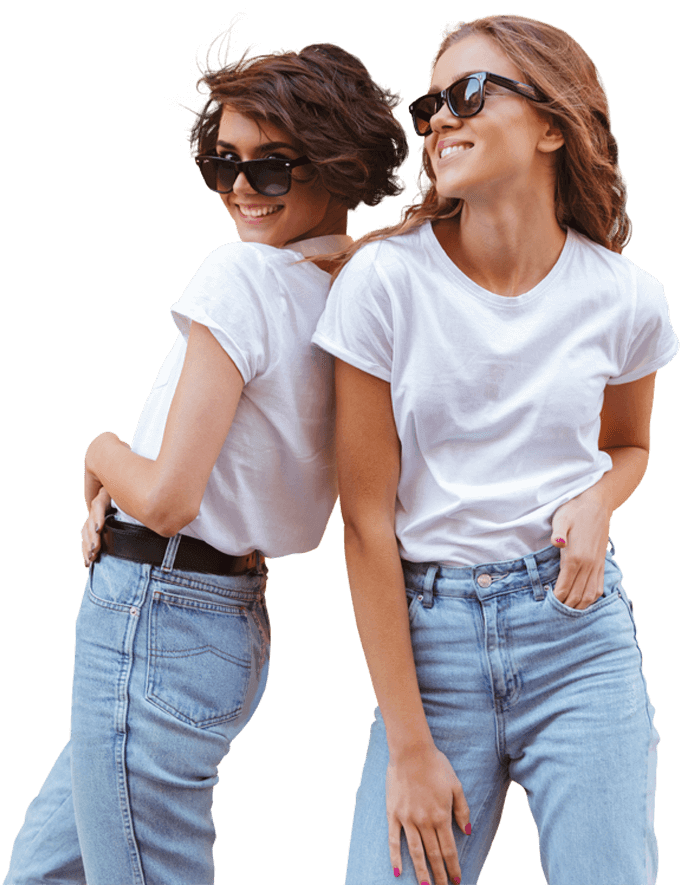 Dos chicas sonrientes con camisetas blancas y pantalones de jean en colo azul claro a juego